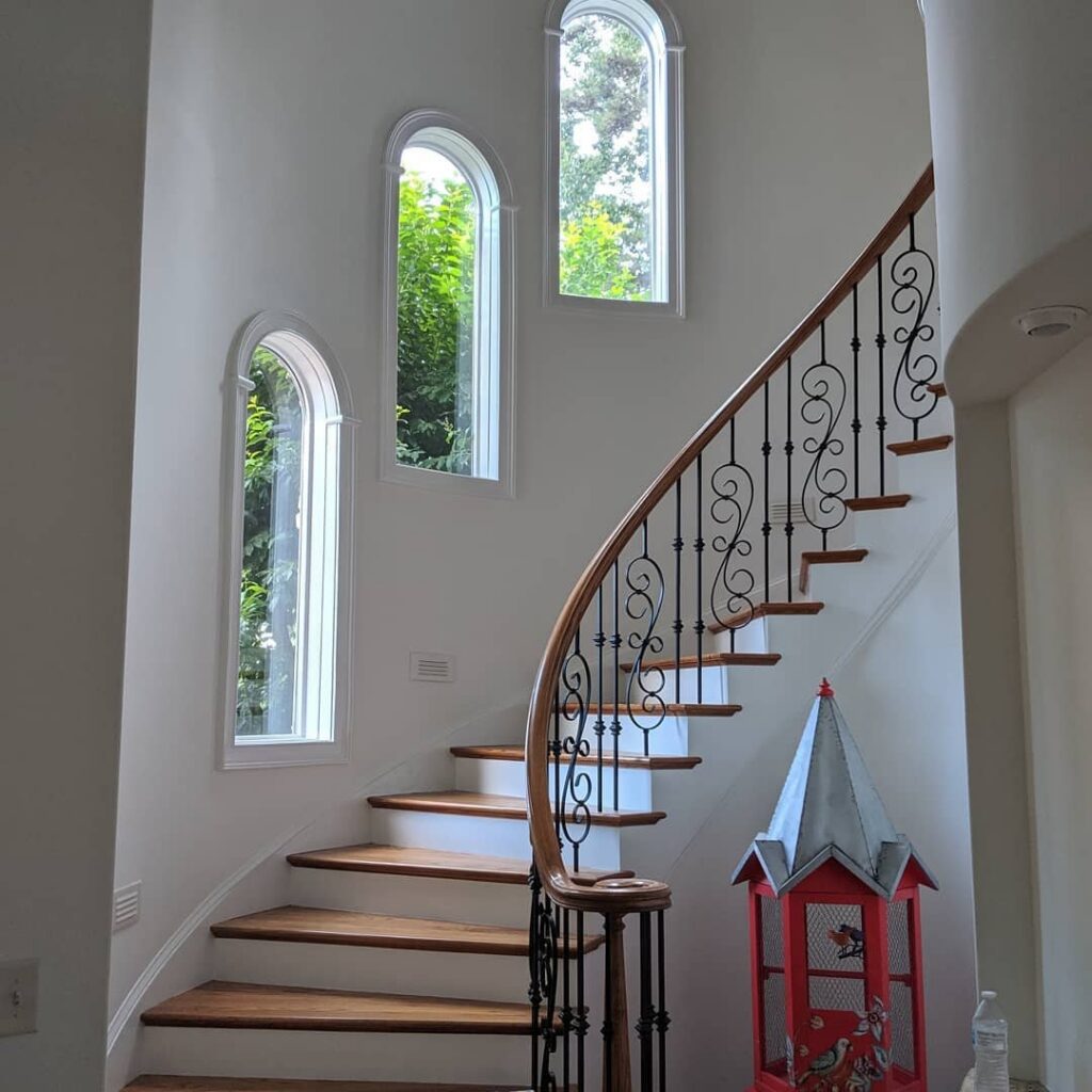 A beautifully painted interior staircase with white walls and wooden steps by Prime Painting in Charlotte, NC.