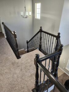 A newly installed interior staircase with dark wood railings by Joe's Handyman Solutions in Ogden, UT.