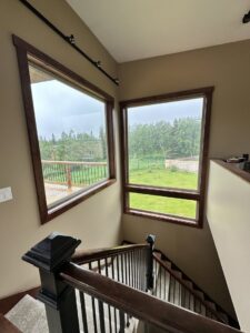 An interior staircase with large windows, showcasing a completed renovation by Alaskan Residential Rescue in Anchorage, AK.