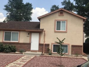 An interior stone fireplace with a wooden mantel and artwork, a renovation by Greg Unseth Painting & Exteriors in Colorado Springs, CO