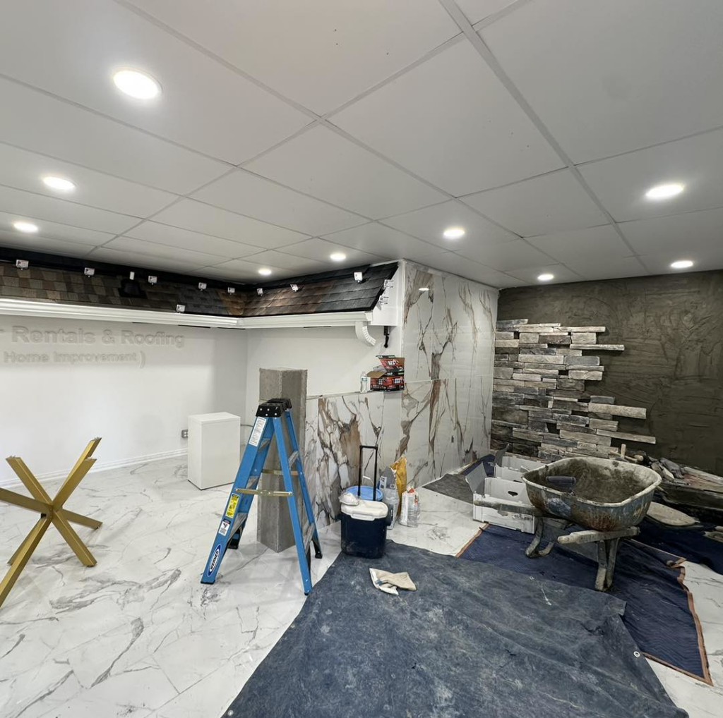 Interior renovation showing tiling and stone work in progress with a ladder and tools by Carolina DR & Roofing in Raleigh, NC.