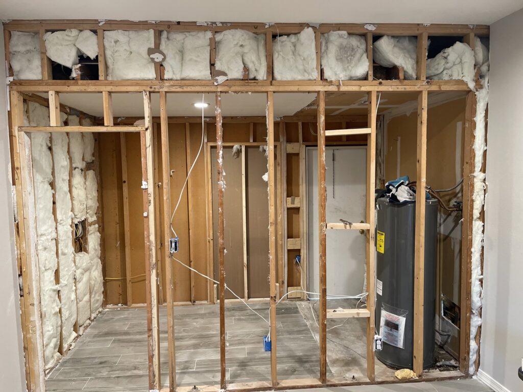 Interior wall framing with exposed insulation during demolition, generating junk for HAVOC Demolition in Scottsdale, AZ.