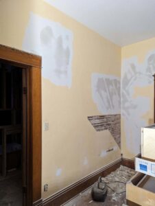 Interior wall showing drywall repair in progress with exposed studs by Friendly Handyman LLC in Wichita, KS