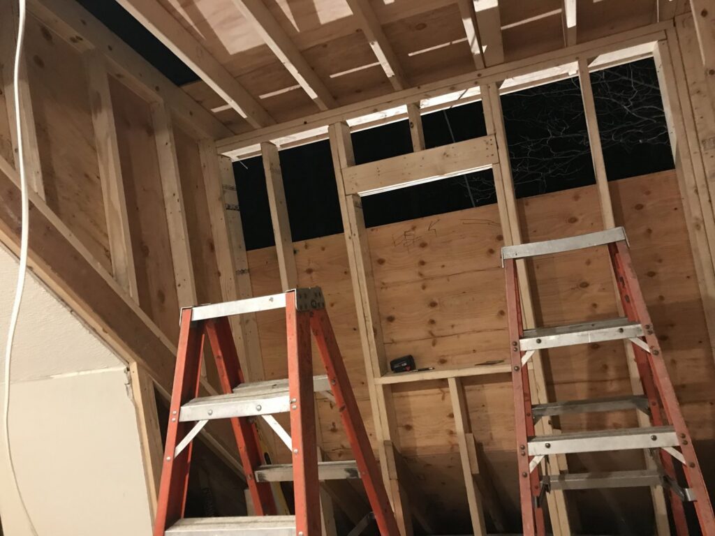 Interior wooden framing for a new wall or room addition, showing ongoing construction by Advanced Seamless Gutters, Inc. in Chicopee, MA.
