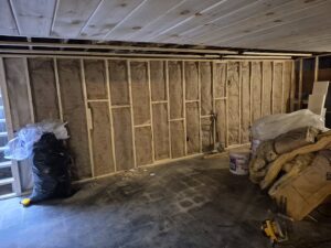 Interior wall framing with insulation installed, ready for drywall, by NED CO. in Springfield, MA.