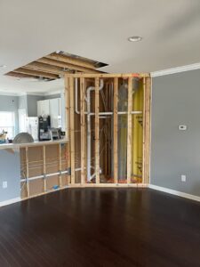 Exposed interior wall framing with visible pipes and insulation during a home renovation by RepairTo Roofing, Renovations & Repairs in Wilmington, DE.