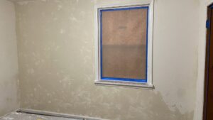 Interior walls prepped for painting or plastering, with a window taped off, by T&K Services in Idaho Falls, ID
