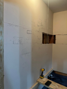 Interior wall with pencil markings and a cut-out, showing renovation planning by Dove Construction and Remodeling in Springfield, MO.
