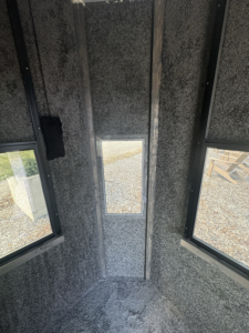 Interior view of a structure showcasing textured gray walls and multiple windows installed by JDM Outdoors of Robinson in Pittsburgh, PA.