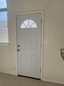 An interior white door with a decorative window, showing a completed installation by Forever Young Handyman Services in Boise, ID.
