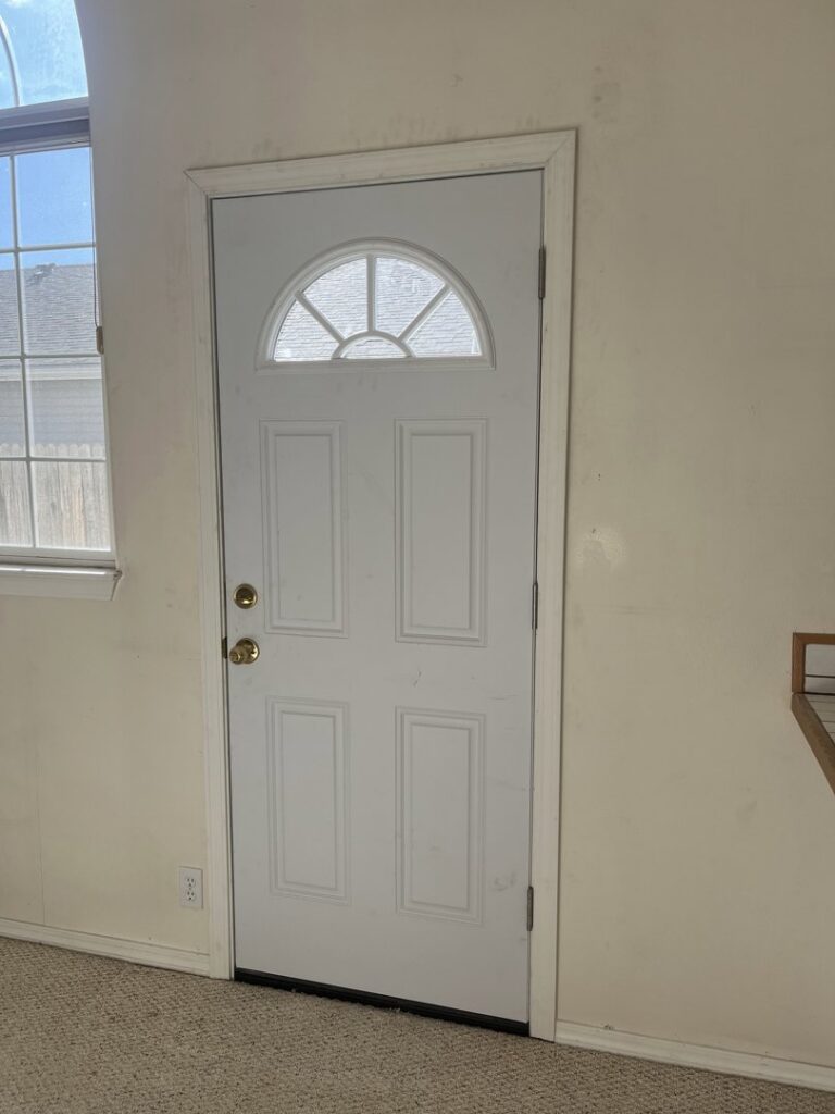 An interior white door with a decorative window, showing a completed installation by Forever Young Handyman Services in Boise, ID.