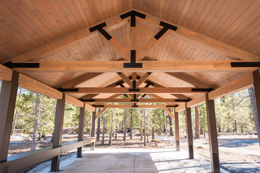 Detailed interior view of a wooden pavilion showing exposed trusses by Winch Construction in Bend, OR.