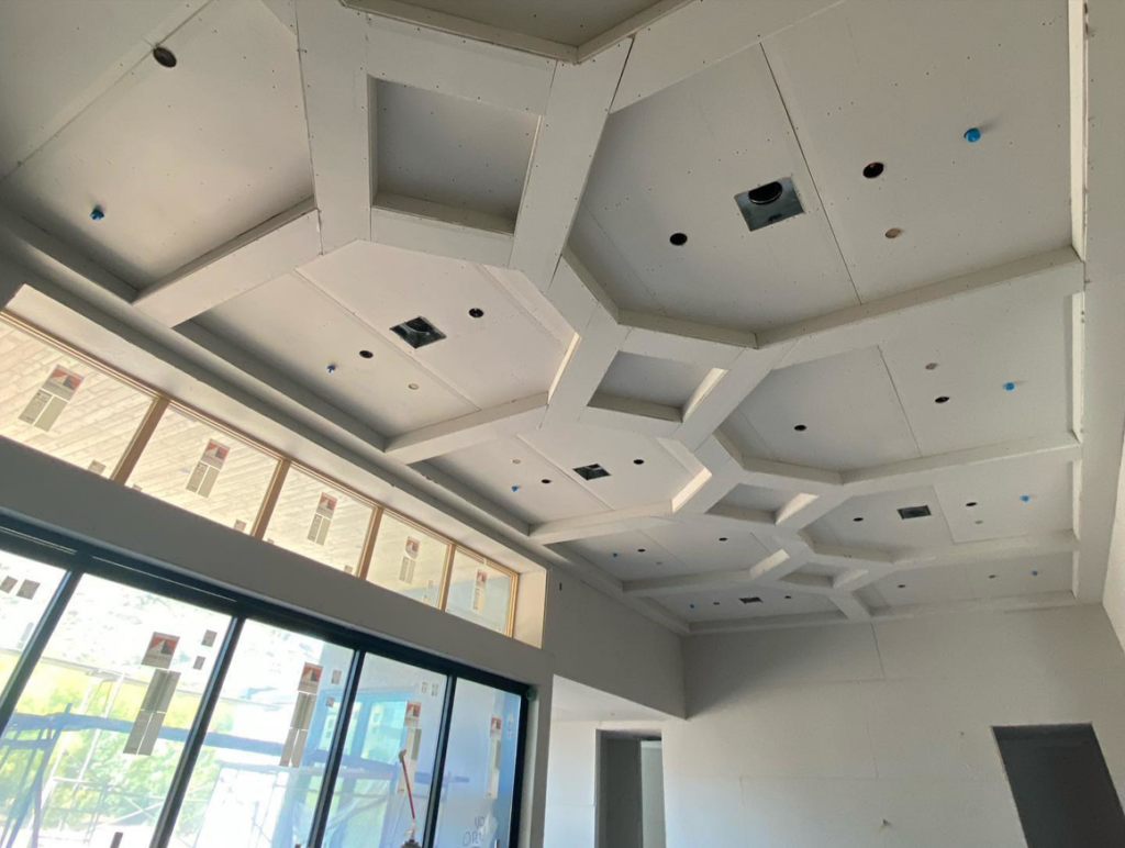 An intricately designed drywall ceiling with recessed lighting being installed by Halo Development Inc. in Gilbert, AZ