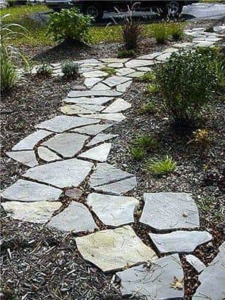 An irregular flagstone pathway winding through a landscaped area by Contractors Stone Supply in Plano, TX