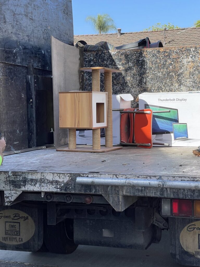 A cat tree, monitor, and other items loaded onto the back of a junk removal truck by Larry The Rubbish Man in Los Angeles, CA.