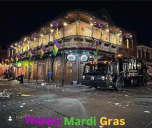 An IV Waste LLC garbage truck on a street covered in Mardi Gras debris in New Orleans, LA, ready for cleanup.