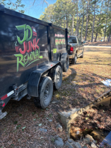 The JD Junk Removal truck and trailer, branded with the business name, parked and ready for service in Raleigh, NC.