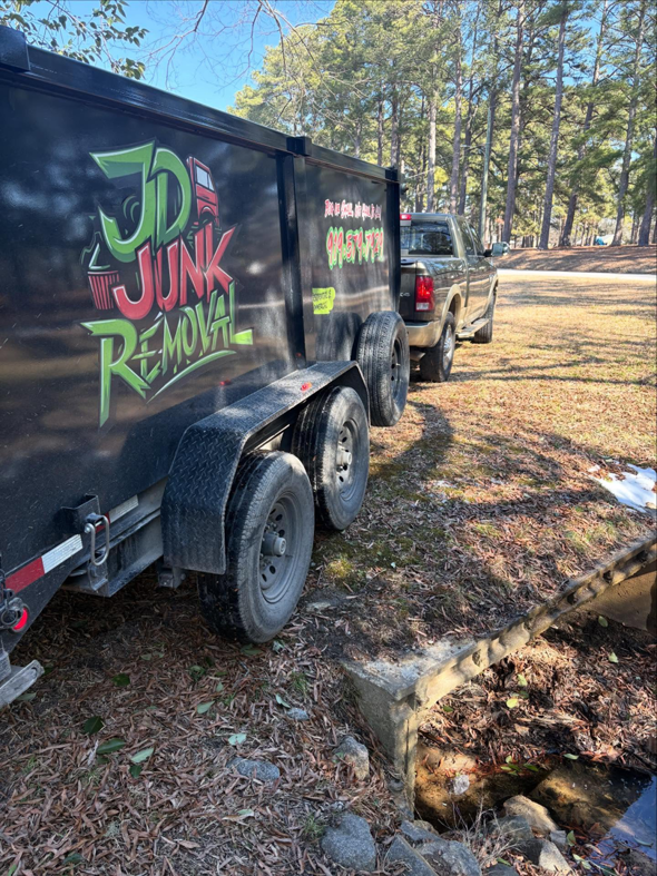 The JD Junk Removal truck and trailer, branded with the business name, parked and ready for service in Raleigh, NC.