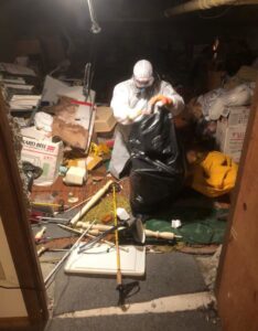 A JDog Junk Removal & Hauling Capital Region NY crew member performing a hoarder cleanout in Schenectady, NY.