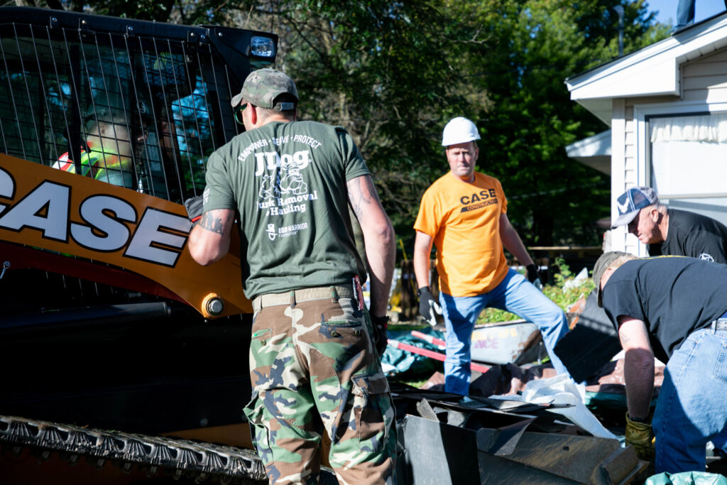 JDog Junk Removal & Hauling Savannah/HHI team members clearing debris with a skid steer loader.
