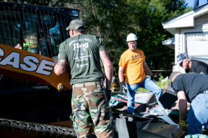 JDog Junk Removal & Hauling Savannah/HHI team members clearing debris with a skid steer loader.