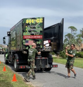 JDog Junk Removal & Hauling Savannah/HHI team members loading various items of junk into a dumpster truck.