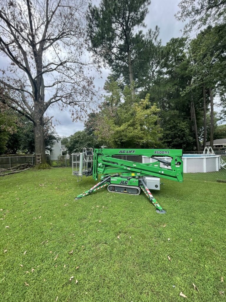 A green JLG spider lift parked on a lawn, ready for tree service by Treetop's Tree Service in Chesapeake, VA.