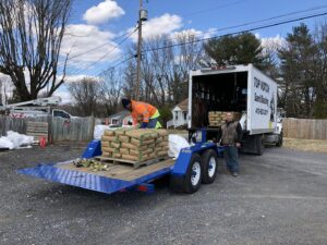 Workers loading materials onto a trailer at a job site for Top Notch Sandblasting LLC in Randallstown, MD