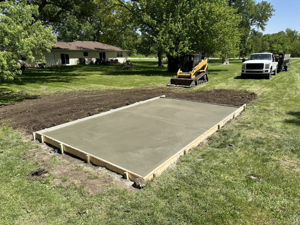 JOCO Services pouring a concrete foundation with wooden forms and a skid steer in Council Bluffs, IA.