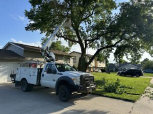 JOCO Services performing residential tree trimming with a white bucket truck in Council Bluffs, IA.