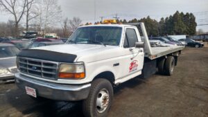 A junk car with its hood open, ready for salvage at First Class Auto Salvage Inc. in Trenton, NJ