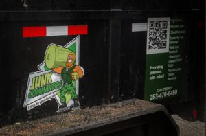 A close-up of a Junk Commandos trailer displaying their logo and a list of junk removal and demolition services in Tacoma, WA.
