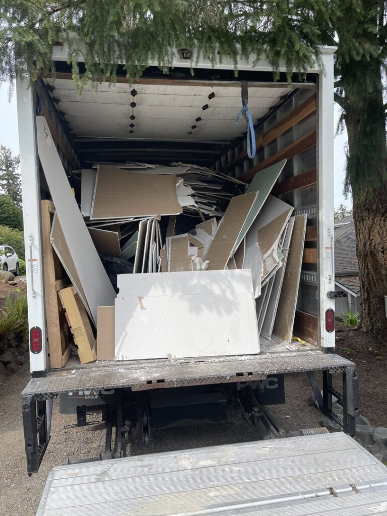 The back of a Junk Commandos truck loaded with construction debris and drywall after a junk removal service in Tacoma, WA.
