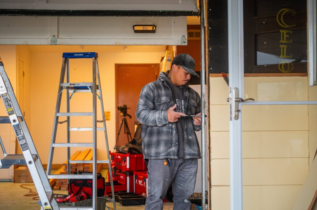 A Junk Commandos worker performing demolition work on a door frame during a junk removal job in Tacoma, WA.