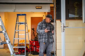A Junk Commandos worker performing demolition work on a door frame during a junk removal job in Tacoma, WA.