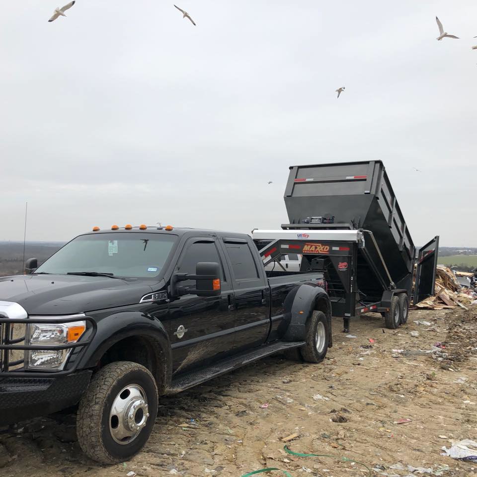 A Trashco DFW truck and dump trailer disposing of collected junk at a landfill in Dallas, TX