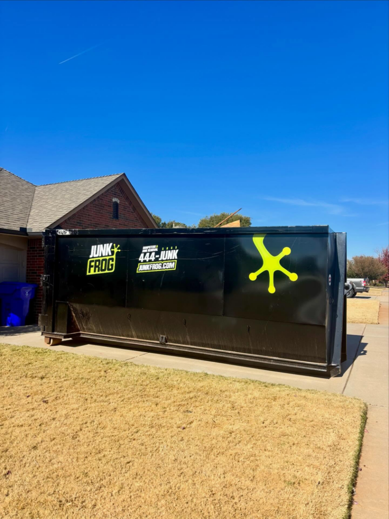 A Junk Frog dumpster rental service container on a residential property in Oklahoma City, OK.