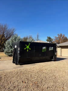 A Junk Frog dumpster on a residential driveway for home cleanout services in Oklahoma City, OK.