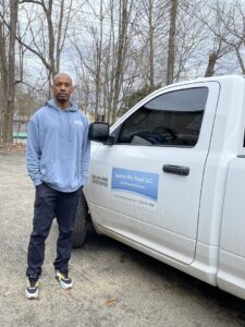 A team member standing proudly next to a Junk in the Truck LLC service truck in Albuquerque, NM, ready for junk removal.
