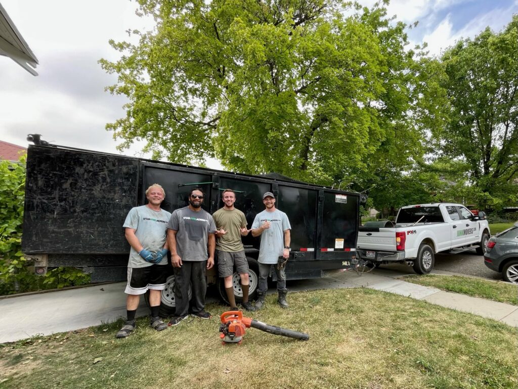The Junk Movers team standing proudly in front of a large trailer filled with junk after a successful removal job in Salt Lake City, UT.