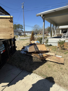 A large pile of cardboard boxes and debris next to a dumpster for removal by Pop & Son's Junk Removal in Montevallo, AL.