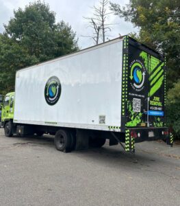 A large white and green box truck branded for junk removal services by K & W Materials & Recycling LLC in Springfield, MA.