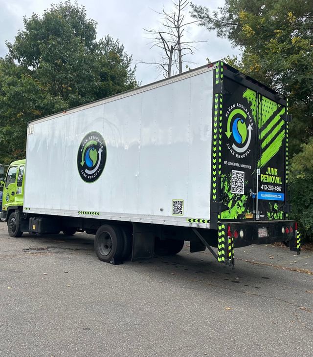 A large white and green box truck branded for junk removal services by K & W Materials & Recycling LLC in Springfield, MA.