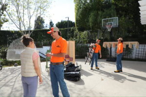 The Junkiez Junk Removal crew interacting with a client while removing junk from a patio in Los Angeles, CA.