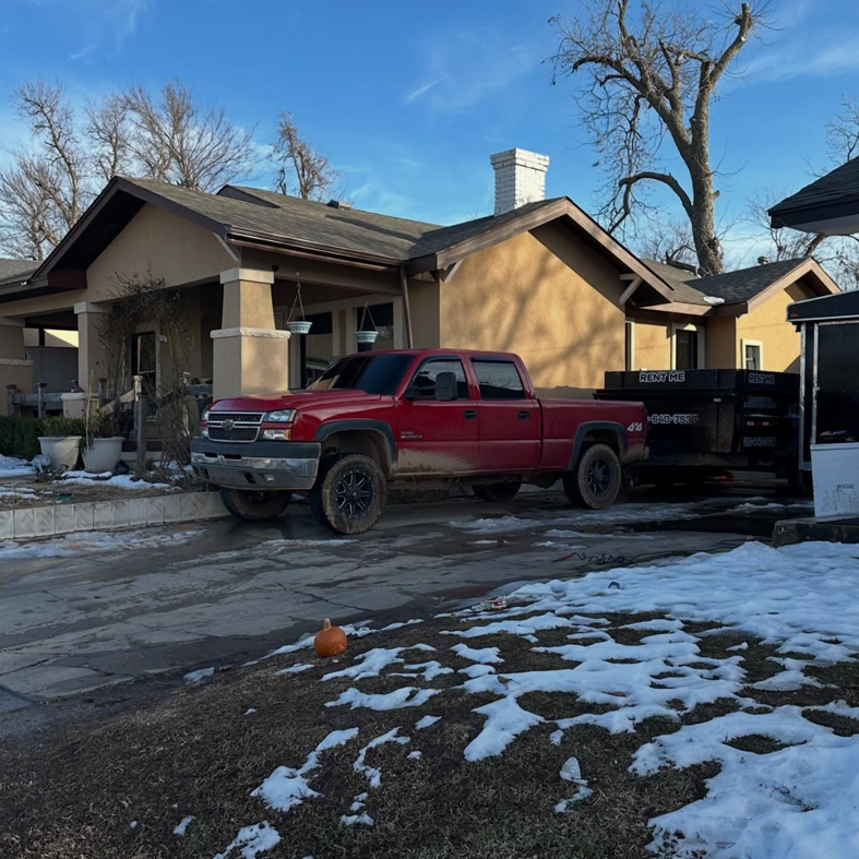 A junk removal dump trailer from Ricky's Dump Truck parked at a residential house in Oklahoma City, OK, for hauling.