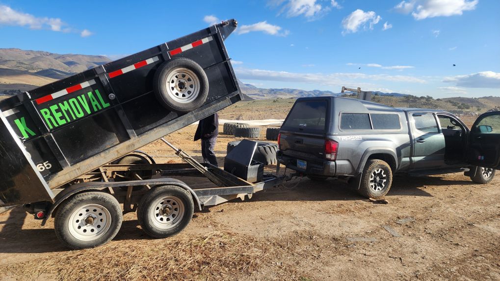A branded junk removal dump trailer being unloaded by Dunk The Junk in Carson City, NV.