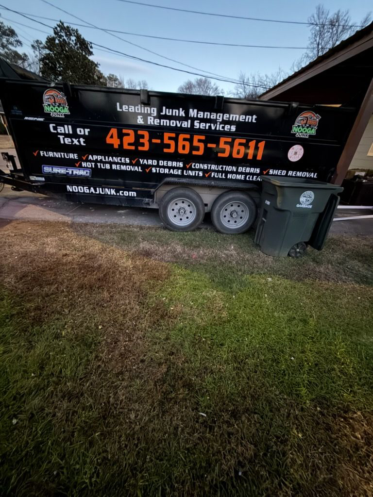 A large junk removal dumpster from Nooga Junk parked on a lawn in Chattanooga, TN, ready for debris.