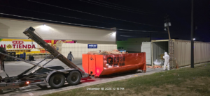 A Rush Disposal LLC team member loading a dumpster with debris onto a truck for junk removal in Laredo, TX.