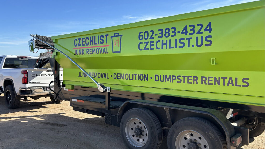 A bright green junk removal dumpster trailer from CzechList Junk Removal attached to a truck in Scottsdale, AZ.
