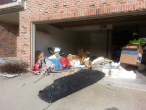 A DFW Service People team member removing boxes and junk from a cluttered garage in Dallas, TX.